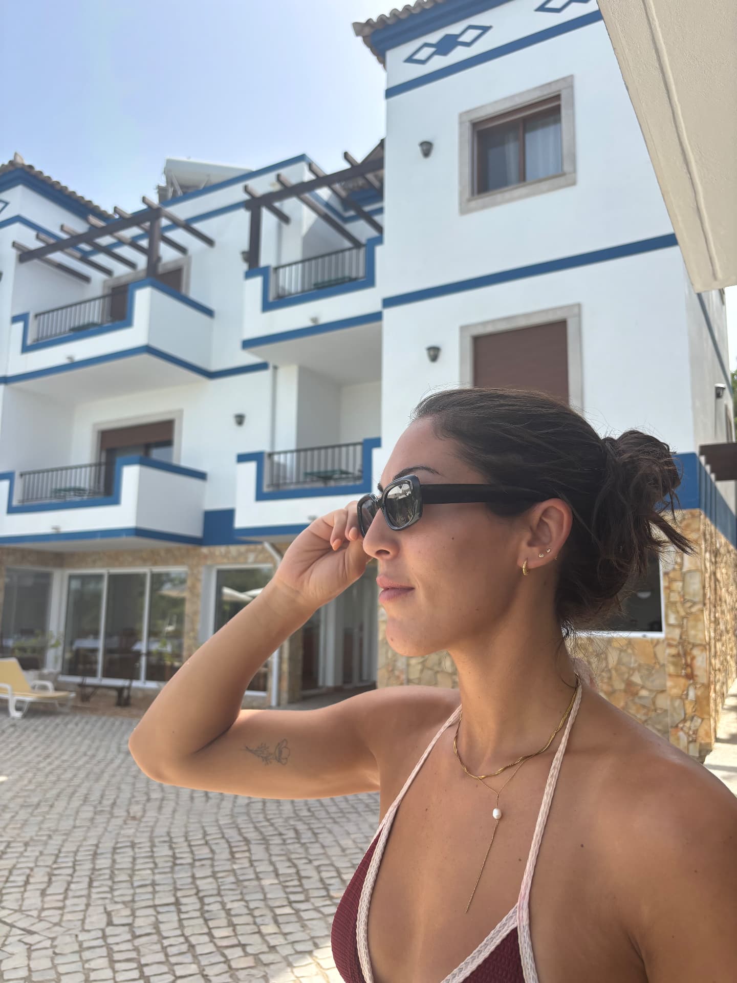 Woman wearing the Obsidian No.1 frame against whitewashed architecture