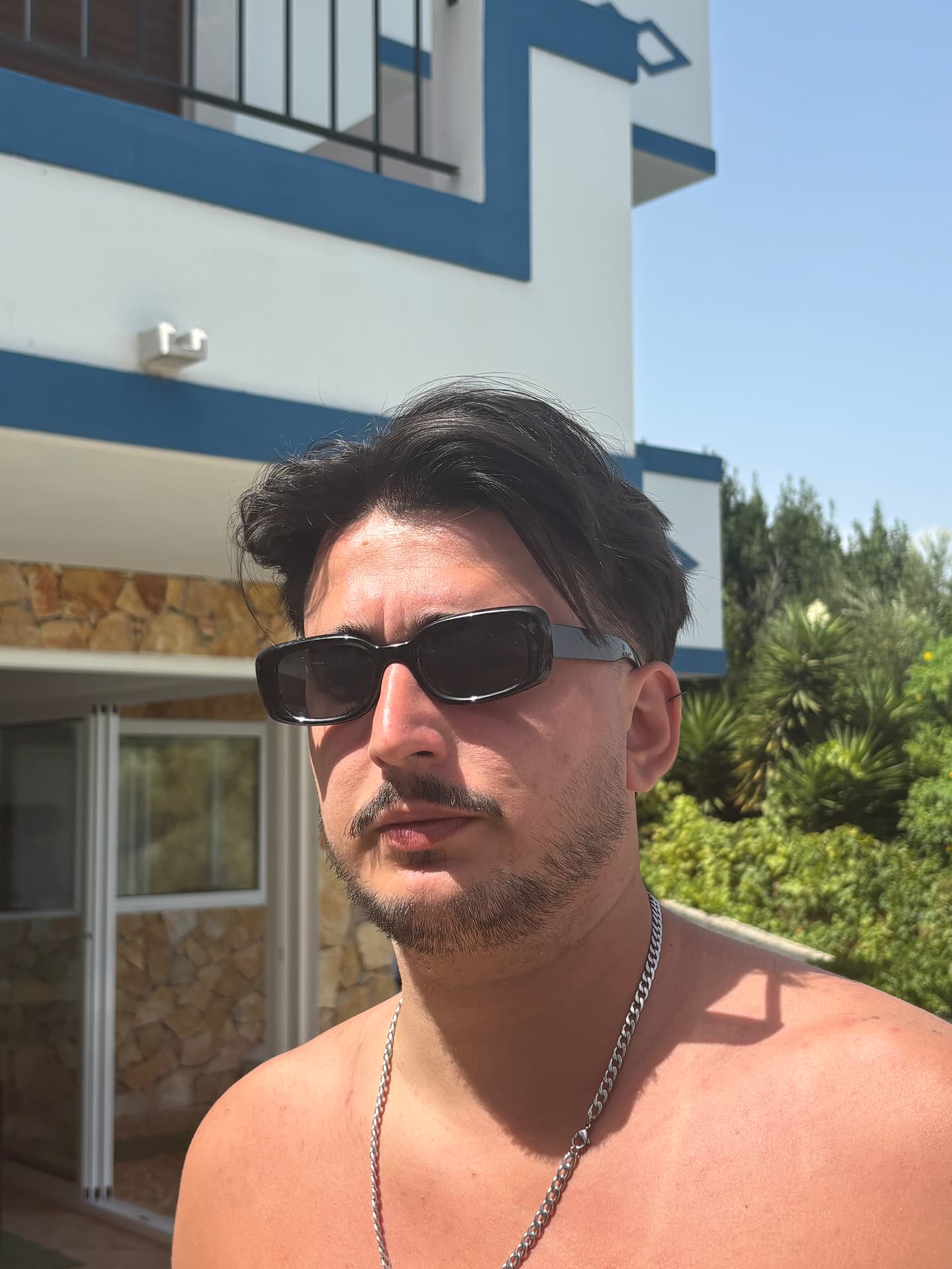 Man wearing the frame in front of a blue-trimmed villa